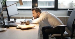 man slumped at desk
