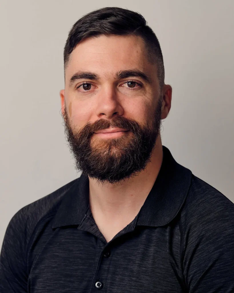 Headshot of Dan Rehder, head physiotherapist and clinic director, smiling in a dark polo.