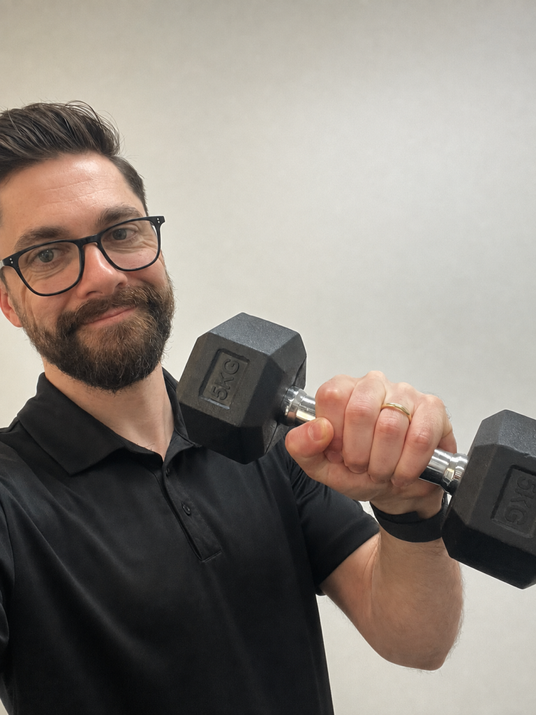 Physiotherapist in a private gym holding a dumbbell at Spine & Dandy in Holland Park West
